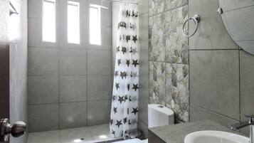 A bathroom with a shower, toilet, and sink.