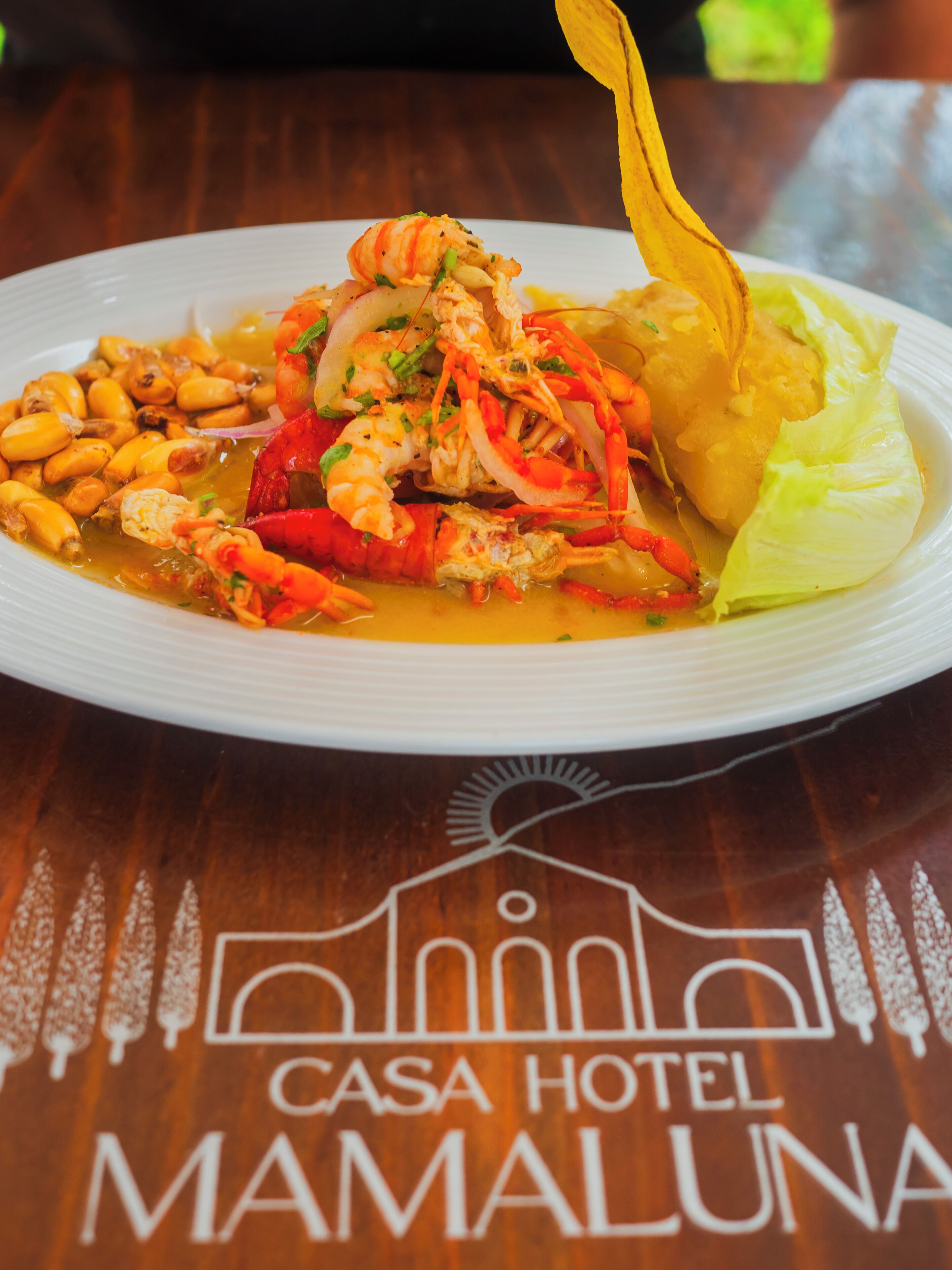 A plate of food with shrimp, beans, and vegetables on a white plate.