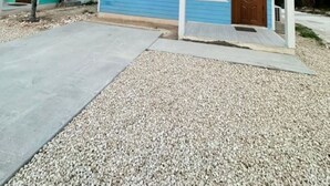 A single-story house with a blue exterior, a front porch, and a gravel driveway. - 5 mins walk or rent a bike to ride to Turtle Beach. (Exuma)