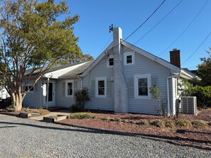 A single-story house with a chimney, a garage, and a tree in the front yard. - Cozy beach cottage, steps from Lewes Beach (Lewes)