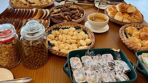 Een buffet met diverse gerechten en een groene wand op de achtergrond.