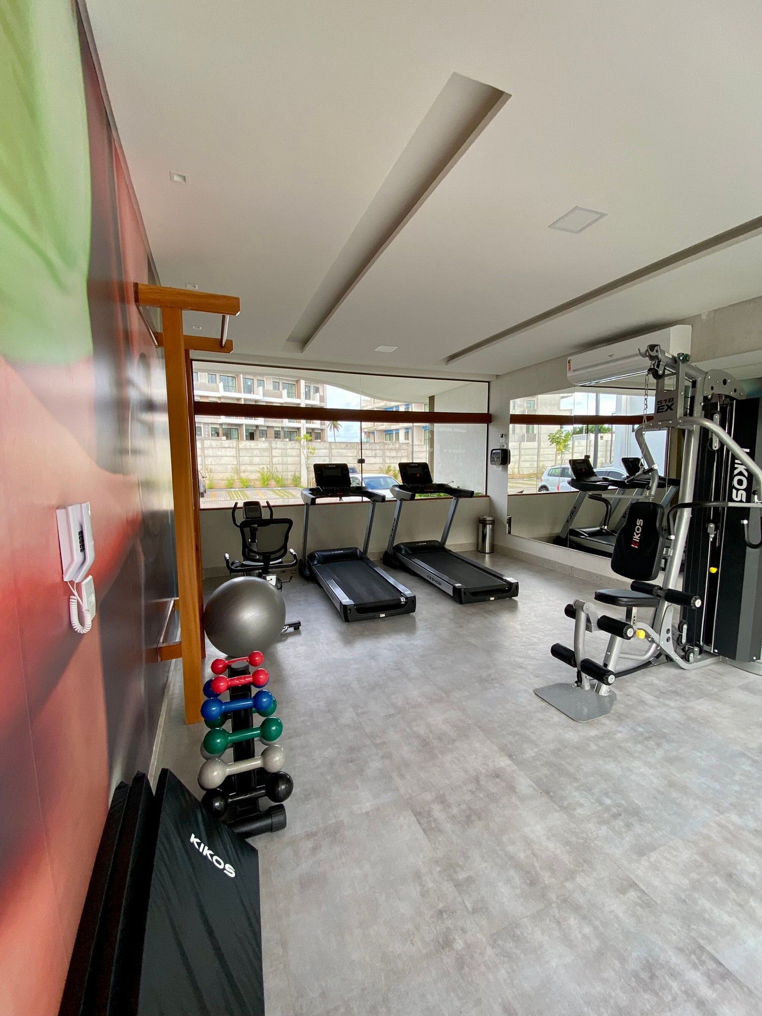 A modern gym with treadmills, weight machines, and exercise balls.