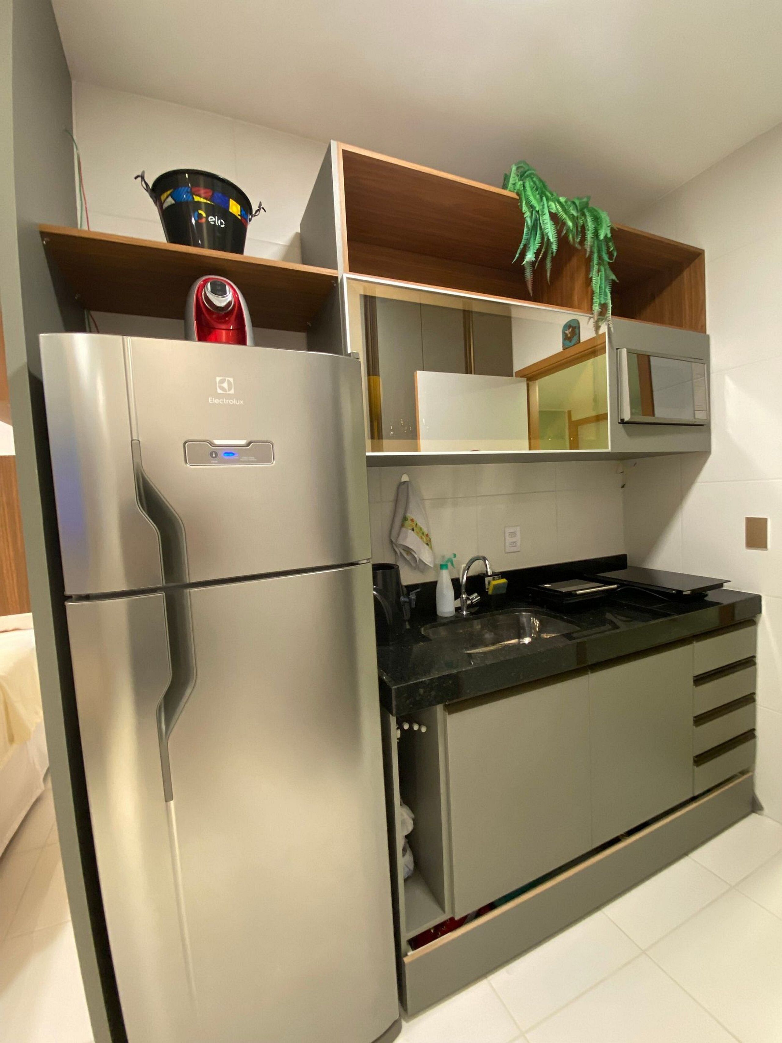 A modern kitchen with a stainless steel refrigerator, a microwave, and a built-in oven.