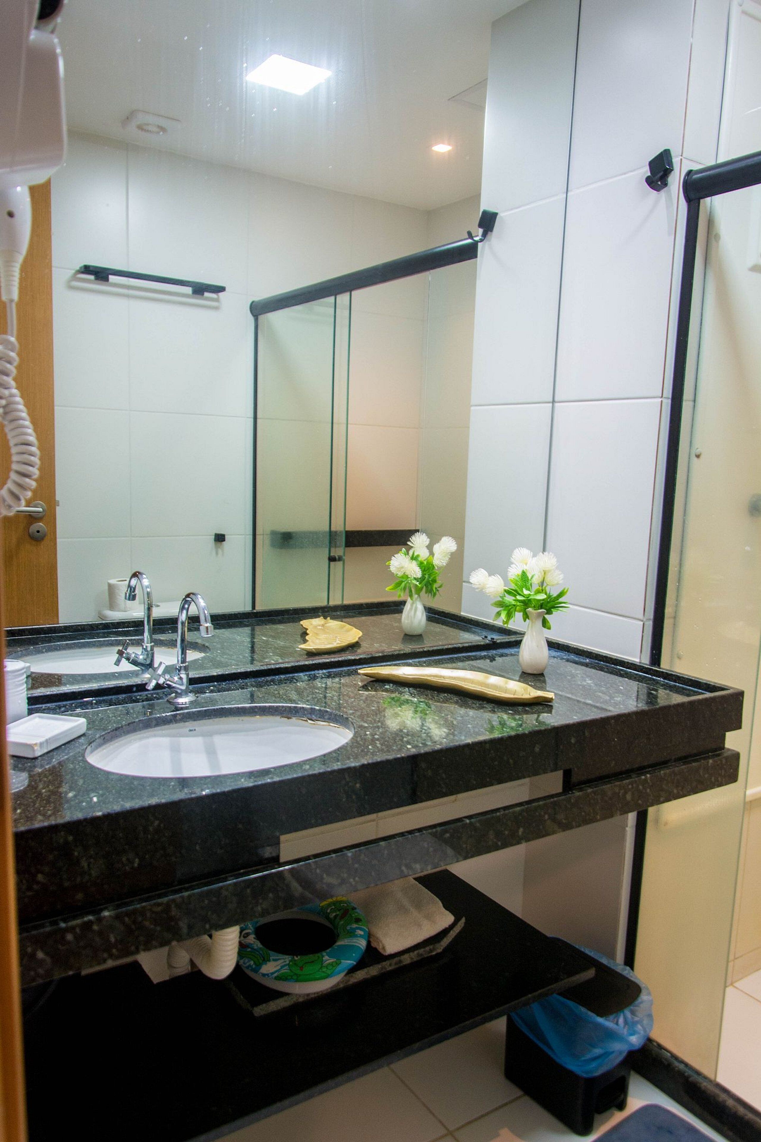 A bathroom with two sinks, a large mirror, and a towel rack.