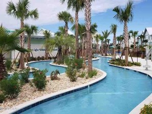 A pool area with palm trees and a clear sky. - 5 O Clock Somewhere (Panama City Beach)