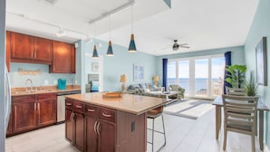 Une cuisine spacieuse avec des meubles en bois, un grand îlot central et des luminaires suspendus.