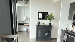 Une cuisine moderne avec des meubles de couleur bois foncé, une table à manger avec des chaises et une plante en pot posée sur le comptoir.
