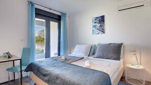 A modern bedroom with a bed, a desk, and a chair. - Villa with swimming pool and playground (Valbandon)