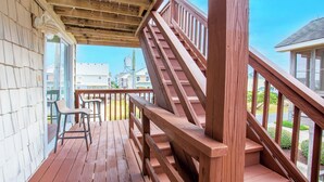 Eine Holzterrasse mit einer Treppe zu einem überdachten Bereich.