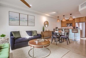 Un salon moderne avec un canapé, une table basse et un coin repas.