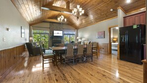 A spacious dining area with a wooden ceiling and a large dining table surrounded by chairs. - Luxurious Adirondack Lodge at Taneycomo with Hot Tub, Stunning Views & Free SDC Tickets (Branson)