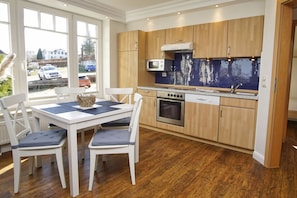 A modern kitchen with wooden cabinets, a built-in oven, and a microwave.
