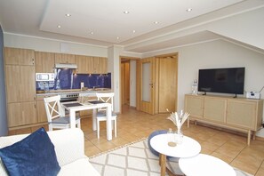 A modern apartment with a kitchen, dining area, and living room. - Die Ferienwohnung Nr. 10 im Haus am Meer - Haus am Meer (Lohme)