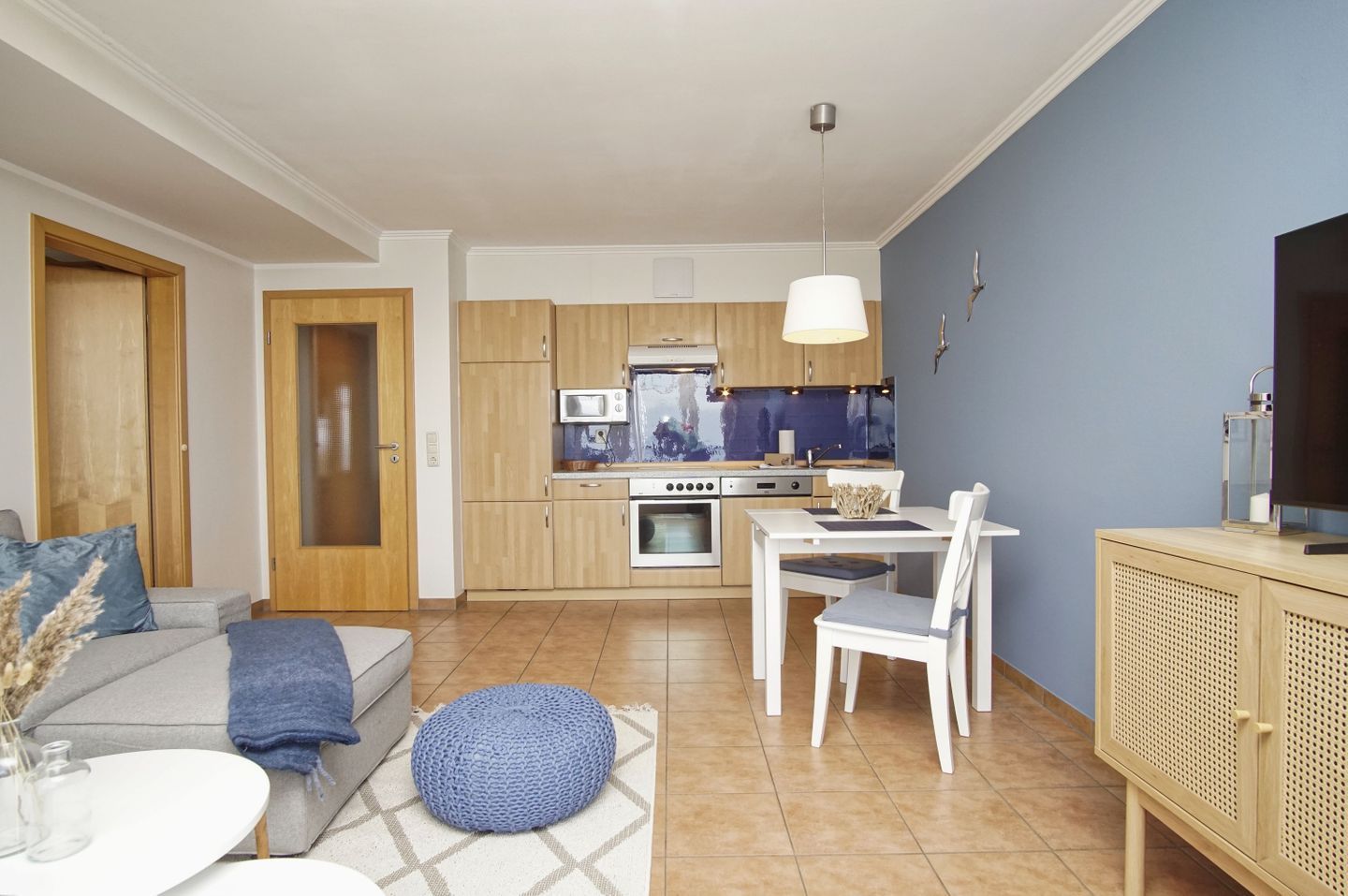 A modern apartment with a kitchen, dining area, and living room.