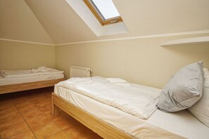 Ein Studentenwohnzimmer mit zwei Einzelbetten, einem Oberlicht und einer Heizung.