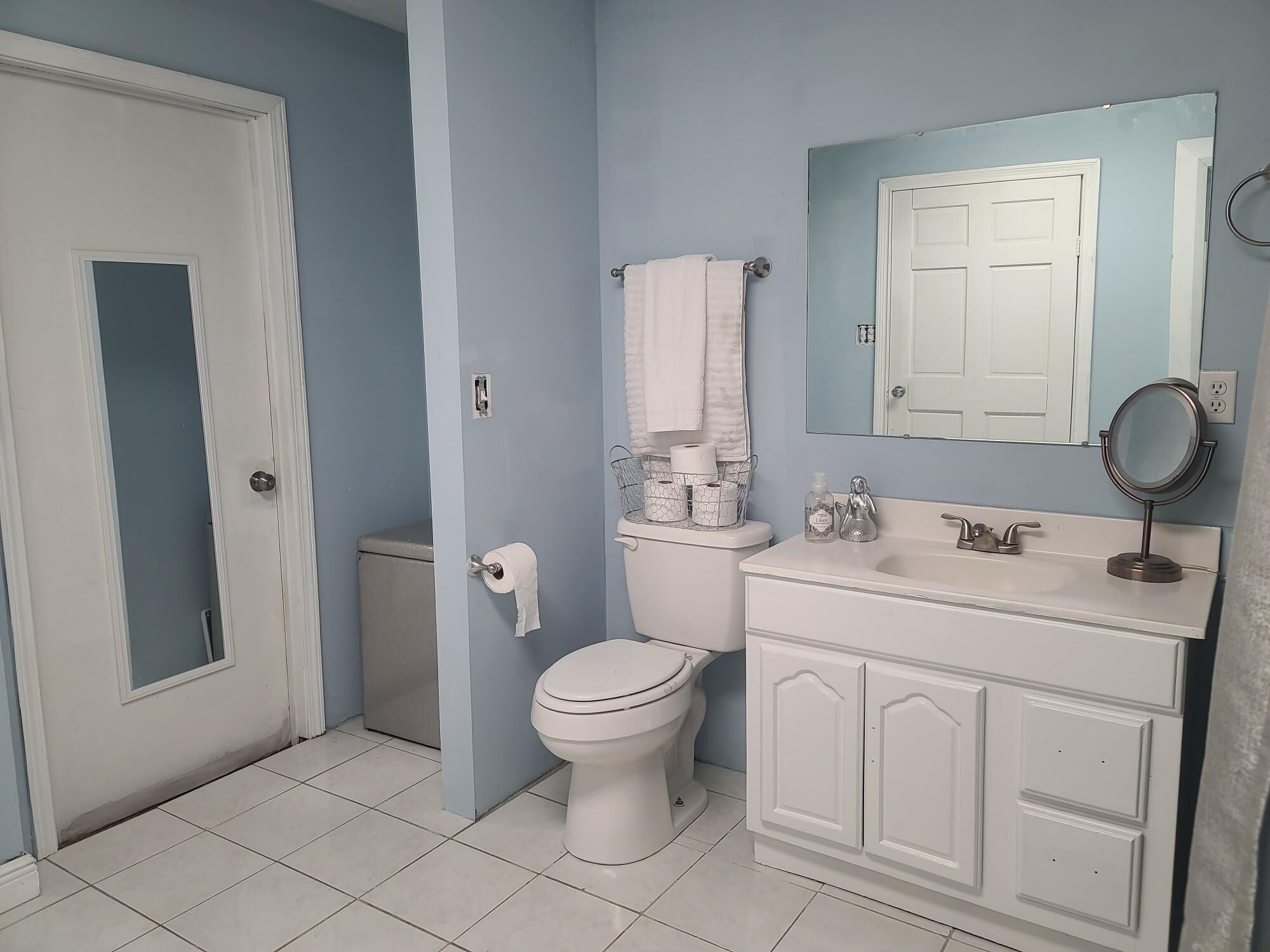 Une salle de bain avec des toilettes, un lavabo et un miroir.