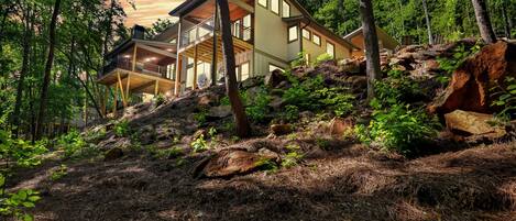 Enjoy a panoramic view of the surrounding woods from the spacious deck and upper-level balcony.