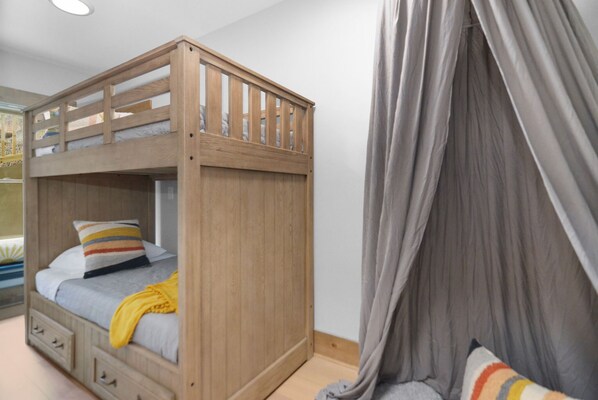 Una cama litera con estructura de madera y dosel.