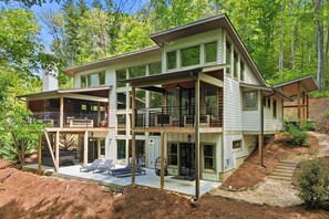 A multi-story house with a balcony, a deck, and a covered outdoor seating area. - Linger Longer ~ Private Creek Access! Hot Tub & Fire Pit (Ellijay)