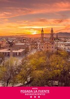 Un hotel con una campana destacada y vistas del paisaje urbano al atardecer.