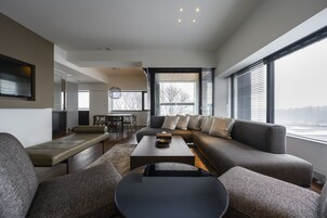 Una sala moderna con un sofá modular, una mesa de centro y un comedor.