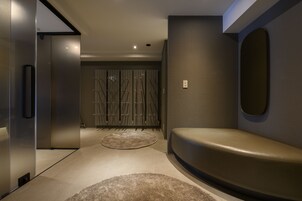 Un intérieur moderne avec un banc incurvé, un tapis rond et un miroir fixé au mur.