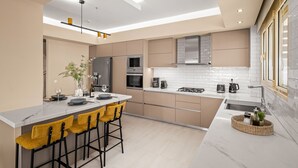Eine moderne Küche mit einer zentralen Kochinsel, Barhocker und einem eingebauten Backofen.