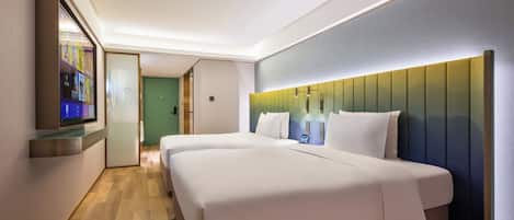Una habitación de hotel con una cama grande, un televisor montado en la pared y piso de madera.