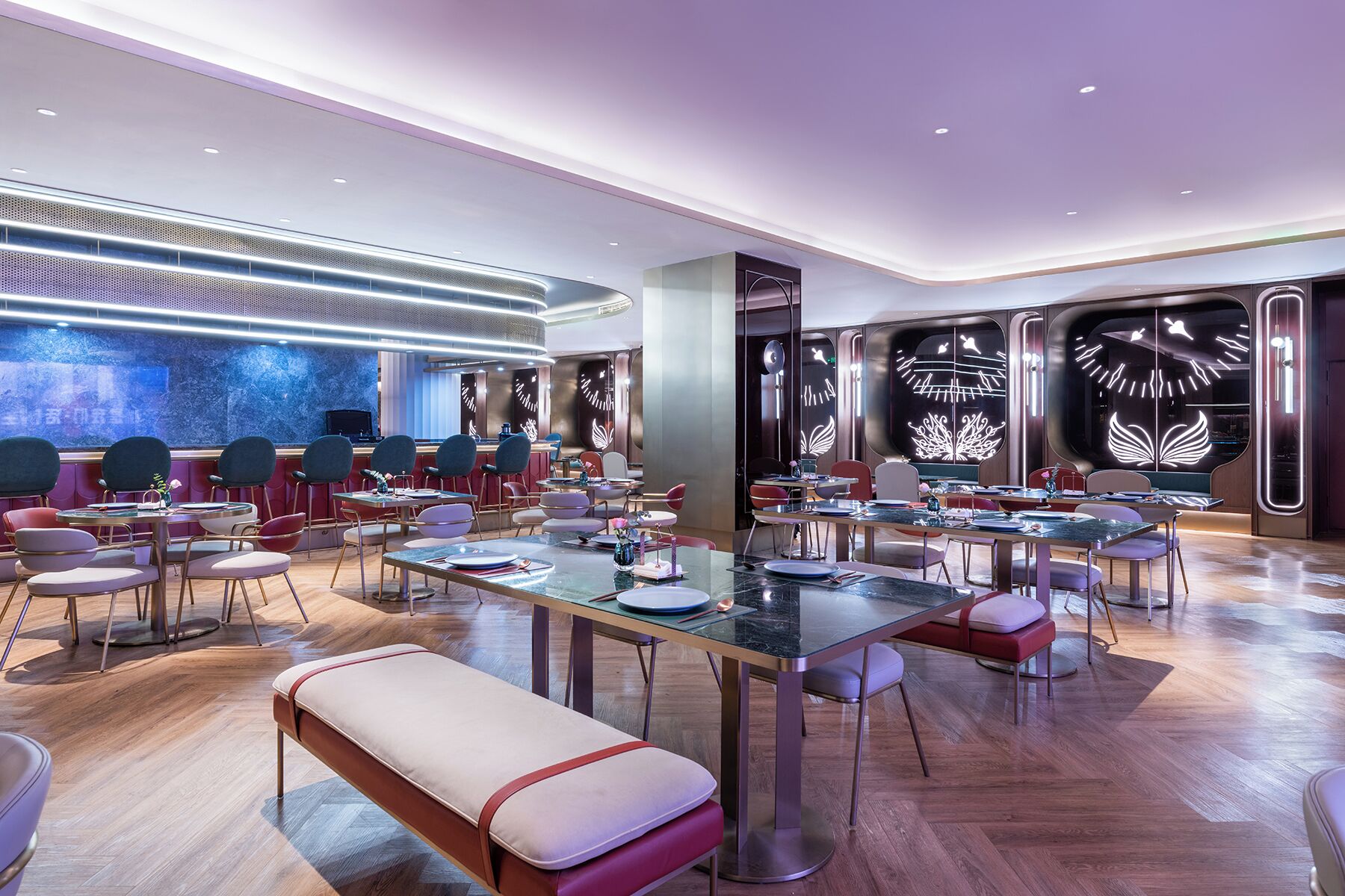 A modern restaurant with round tables, bar seating, and decorative wall panels.