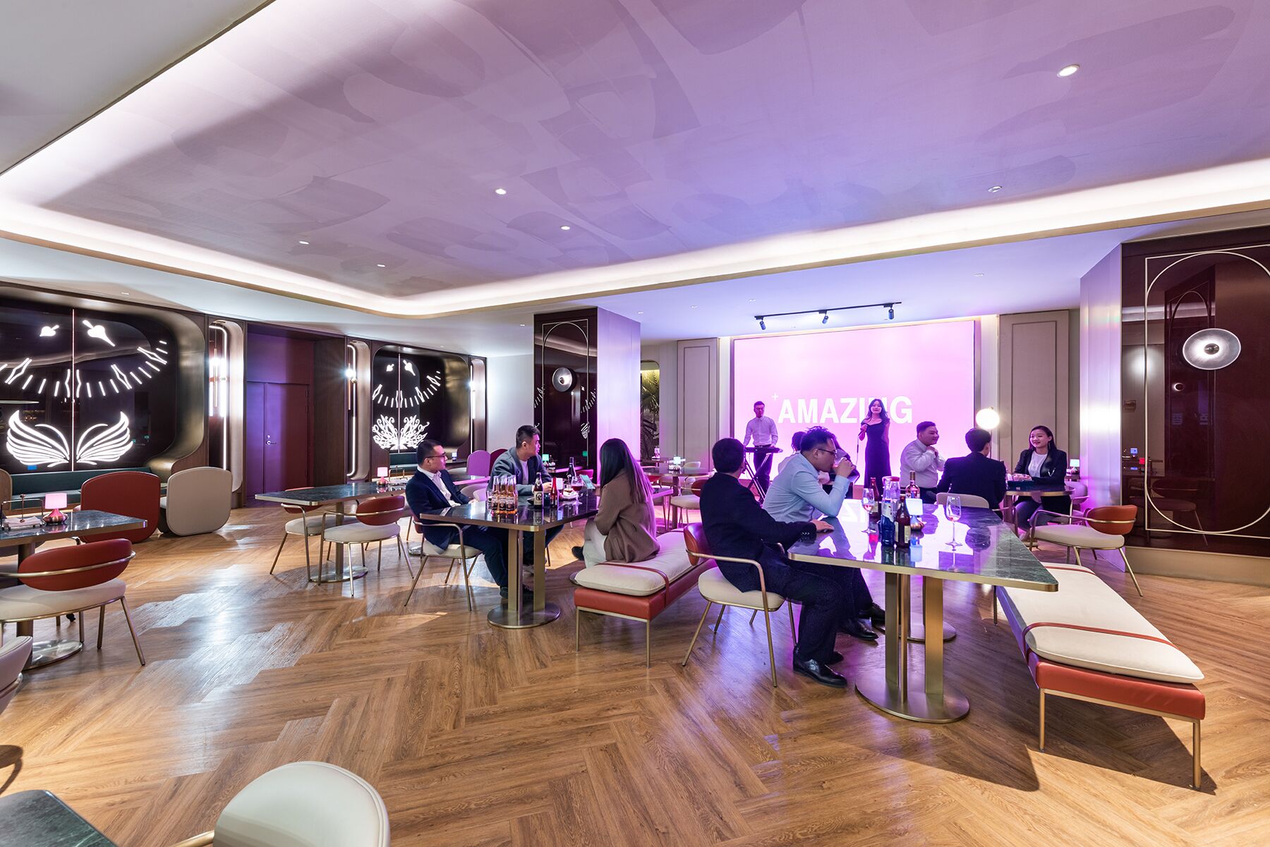 A modern conference room with a large table, comfortable seating, and a large screen displaying the word "AMAZING".