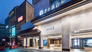 A hotel with a modern facade, large windows, and a prominent signage.