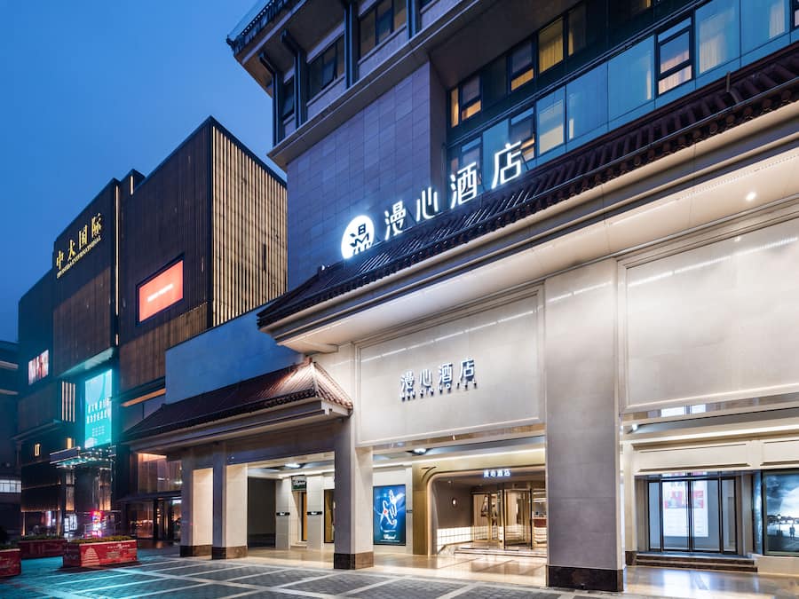 A hotel with a modern facade, large windows, and a prominent signage.
