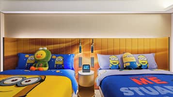 Een hotelkamer met twee bedden, elk voorzien van beddengoed met Minion-thema.
