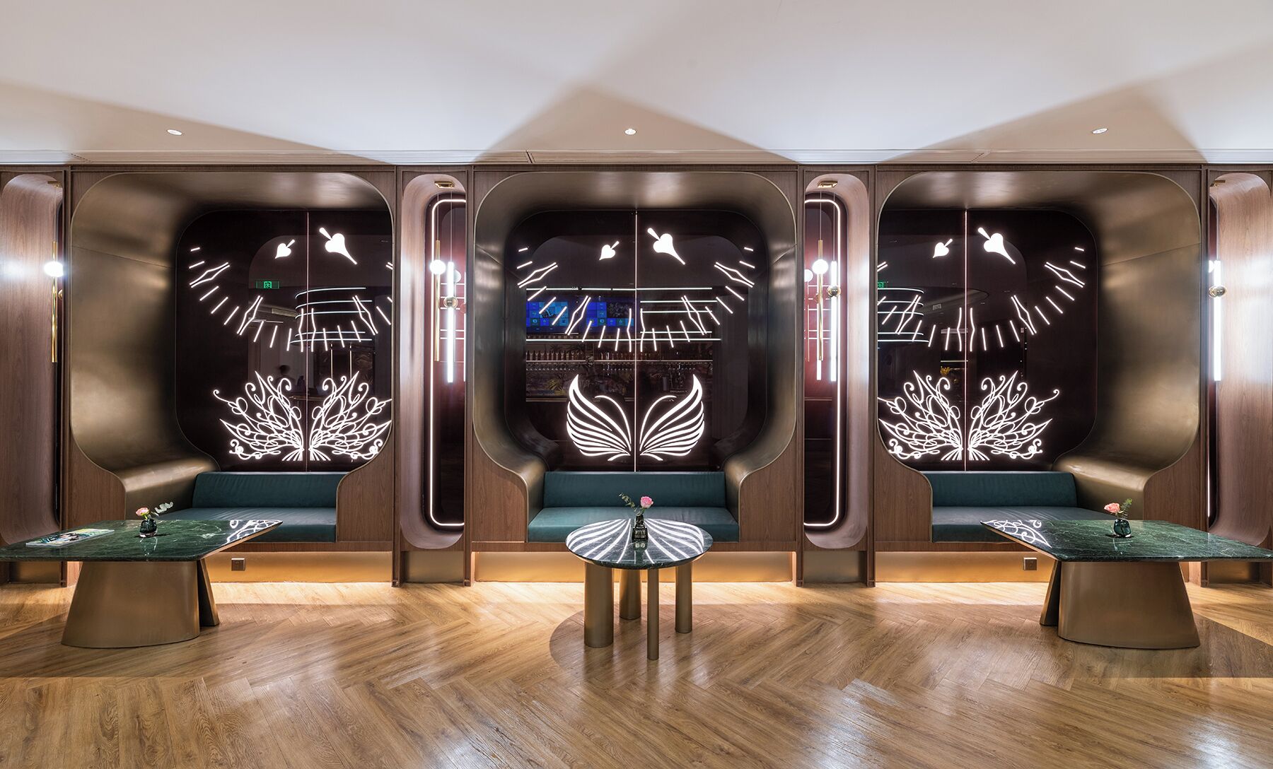 A lobby with three seating areas, each with a unique illuminated design on the back wall.