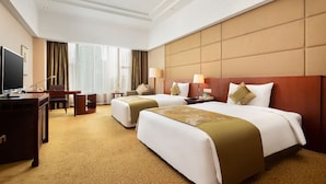 A hotel room with two beds, a desk, a TV, and a large window with curtains. - Foshan Golden Hotel (Foshan)