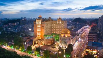 A large hotel with multiple floors and a prominent dome structure, surrounded by a busy urban area with visible roads and other buildings.
