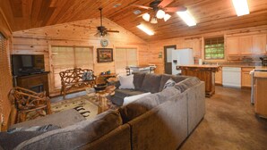L’intérieur d’une cabane en rondins comprend un salon, une cuisine et un coin repas.