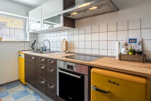 A modern kitchen with a dishwasher, oven, and a yellow refrigerator.