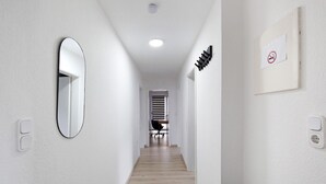 A hallway with a mirror, a no-smoking sign, and a desk with a chair. - Apartment 'Zur Nordhelle' with Mountain View and Wi-Fi (Herscheid)