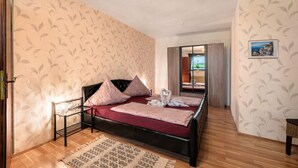 A bedroom with a bed, pillows, a bedside table, a rug, and a wall with a leaf pattern. - "Pesch" Holiday Apartment with Shared Terrace (Nettersheim -Pesch)