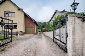 A gravel driveway leading to a gated entrance with a brick wall and a metal gate. - Apartment "Pesch" with Shared Terrace & Wi-Fi (Nettersheim -Pesch)