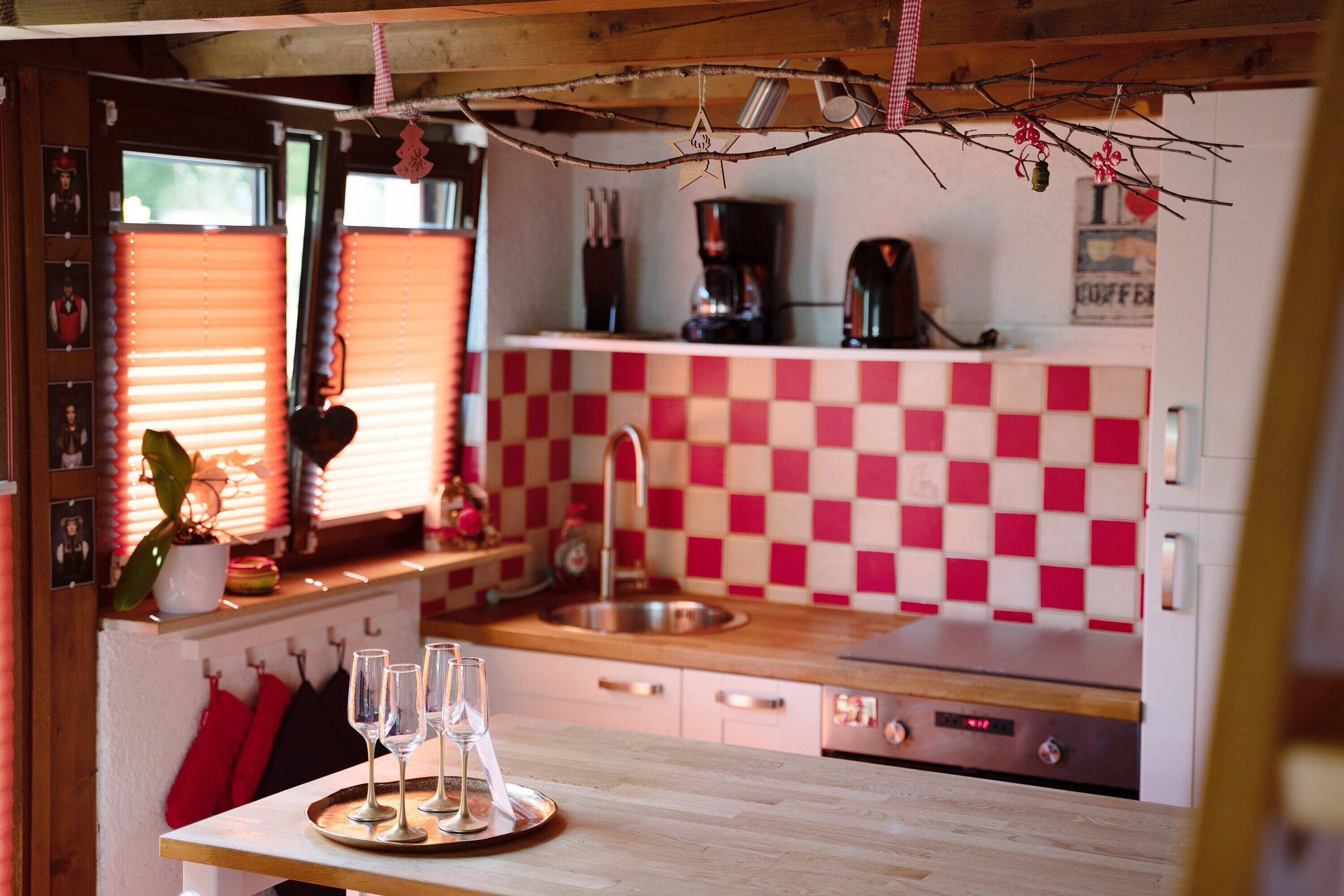 Une cuisine avec un dosseret à carreaux, une machine à café et un évier.