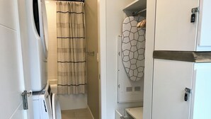 A bathroom with a shower, a towel rack, and a toilet. - 🦊Tiny, Mighty Studio in Canmore🦊  (Canmore)