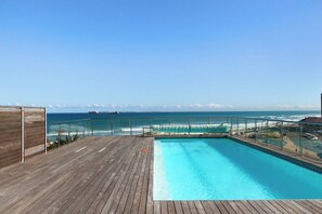 Un pontile di legno con piscina che si affaccia sull'oceano.