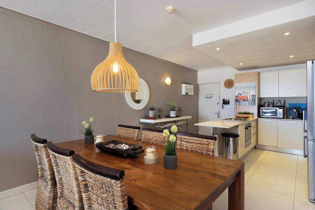 A modern kitchen with white cabinets, a microwave, and a refrigerator.