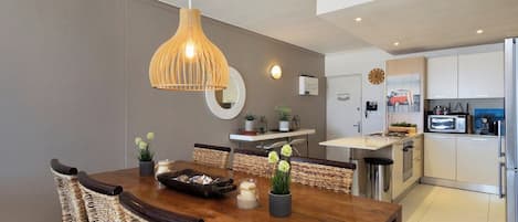 A modern kitchen with white cabinets, a microwave, and a refrigerator.