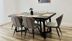 A dining area with a round table, six chairs, a chandelier, and a painting on the wall. - StarryNight @ Museum Park -WORLD CUP- Walk to Museums, Hermann Park, Zoo, Dining (Houston)