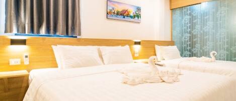 A hotel room with a large bed, two bedside tables, a painting on the wall, and a window with curtains.