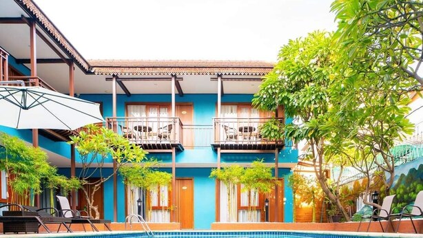 A hotel with a swimming pool, balconies, and lush greenery. - New Champa Boutique Hotel (Vientiane)