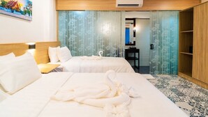A hotel room with two beds, a wooden headboard, a painting on the wall, and a bathroom visible through a glass door. - New Champa Boutique Hotel (Vientiane)
